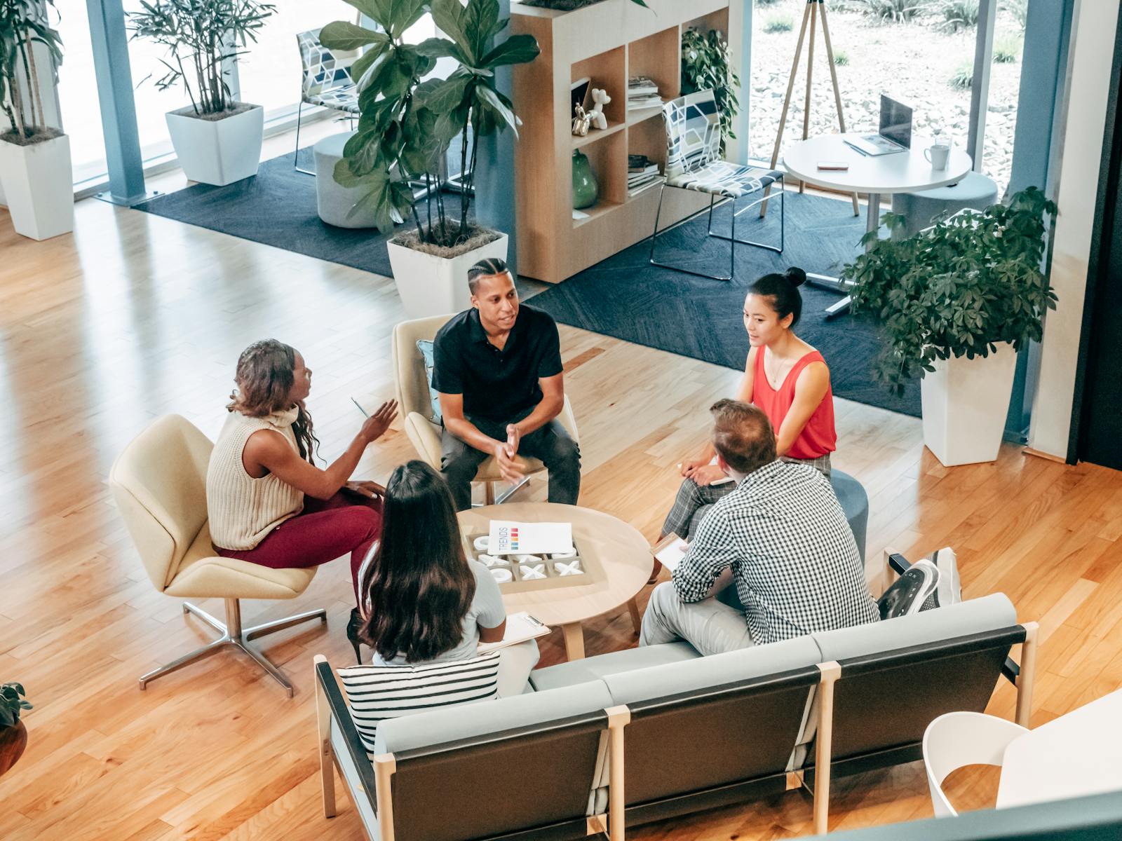 Un groupe diversifié de professionnels participe à une réunion d'équipe collaborative dans un environnement de bureau élégant.